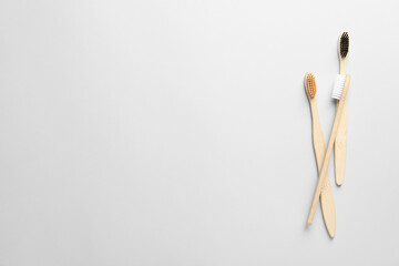 Bamboo toothbrushes on white background, flat lay. Space for text