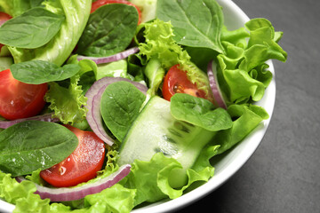 Delicious vegetable salad on grey table, closeup