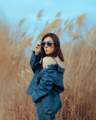 Funny Pretty Fashion Woman Wearing Statement Sunglasses and Denim Outfit. Attractive self-confident girl posing quirky and cool 
