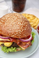Delicious burger with bacon, patty and vegetables on table, closeup