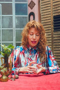 adult tarot reader woman at home mixing cards to start reading, vertical image