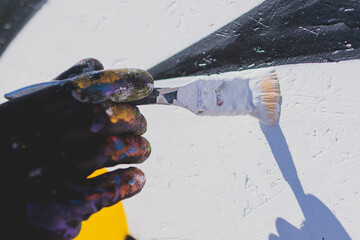 Process of creating graffiti, street artist with aerosol spray paint painting colorful stencil...