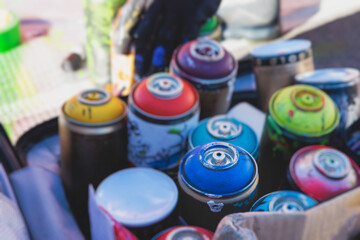 Equipment set for street art, spray cans bottles with aerosol spray paint, creating graffiti and mural on the walls, with paint can, brush, roller, street artist kit for stencil murals and grafiti