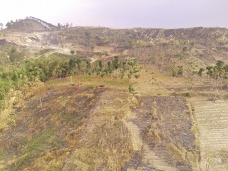 Aerial Photography. Aerial Drone view of the barren and dry landscape of Mount Pangradinan, Cikancung - Bandung, Indonesia. A barren mountain and a source of mining for local resident