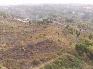 Obraz premium Aerial Photography. Aerial Drone view of the barren and dry landscape of Mount Pangradinan, Cikancung - Bandung, Indonesia. A barren mountain and a source of mining for local resident