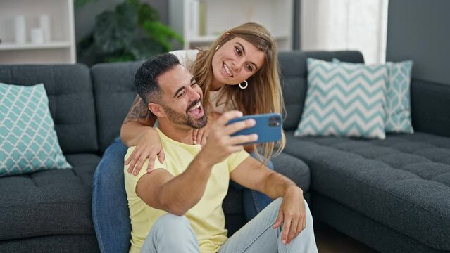 Man and woman couple make selfie by smartphone sitting on sofa at home