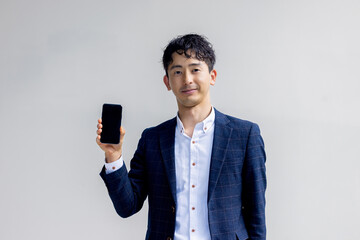 スマホを持って案内をする男性ビジネスマン