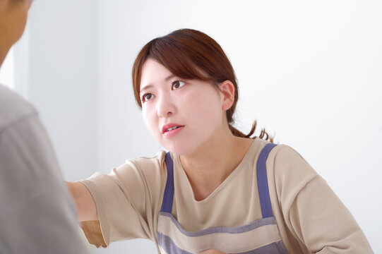 怒りをあらわにする若いエプロン姿の女性