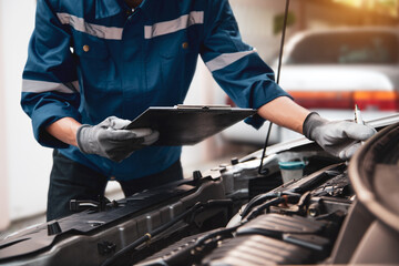 Car care maintenance and servicing, Hand technician auto mechanic checking inspection list after fix or repairing change spare part car engine problem and car insurance service support assistance. - Powered by Adobe