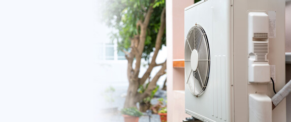 Air compressor external split wall type of outdoor home air conditioner unit installed on outside building. Concepts of cool or heat or hot and air conditioning system maintenance service cleaning. - obrazy, fototapety, plakaty