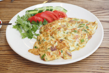 Plain Egg Omelette and fresh salad for breakfast on table 