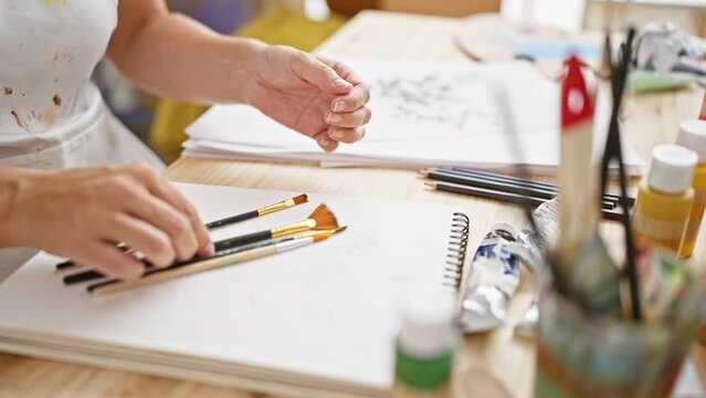Passionate woman artist's hands vigorously cleaning paintbrushes amidst the reverie of her art studio