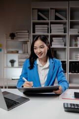 Business woman working in a startup company, female accountant working in auditing the company's...