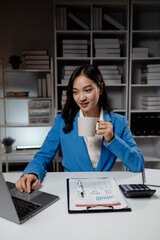 Business woman working in a startup company, female accountant working in auditing the company's...