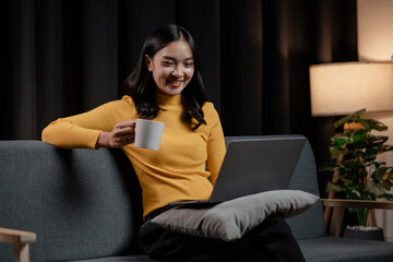 Obraz premium Asian woman relaxing on sofa in house, businesswoman spends her vacation watching movies, listening to music and surfing social media on smartphone, texting and chatting with friends. Weekend concept.
