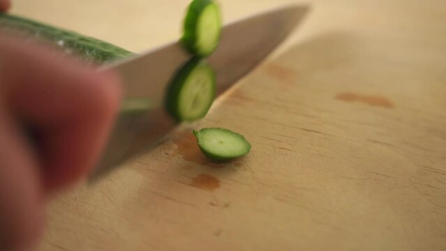 Chopping green cucumber in close up
