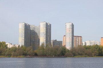 View of residential buildings on the shore of a pond in a landscape park, Yuzhnoye Butovo, Moscow, October 2023.