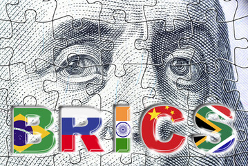 The word BRICS with flags of each countries on US dollar. BRICS nations are exploring strategies to reduce reliance on the US dollar, potentially challenging its dominance in global trade and finance.