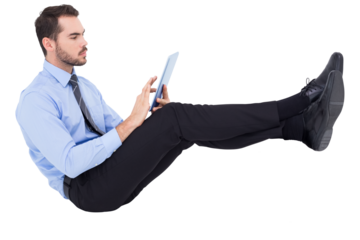 Digital png photo of caucasian businessman sitting and using tablet on transparent background
