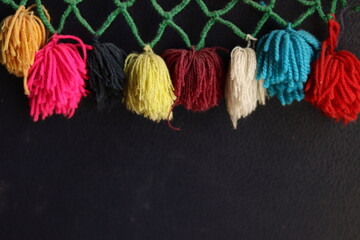 Rainbow colour Yarn Tassel Garland stitched to a piece of cloth