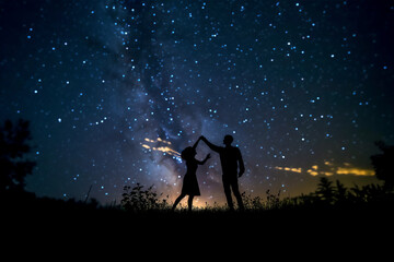silhouette of a couples dancing at night.