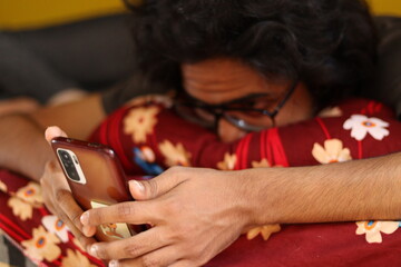 An Indian boy using the Smartphone while wearing a goggle with full focus and layer down