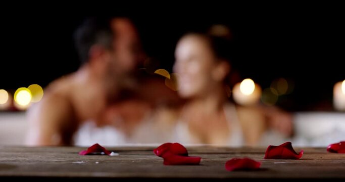Candle, rose petals and hot tub couple romance, relax and bonding in Valetines Day date conversation. Love, partner wellness and relationship man, woman or marriage people discussion in night jacuzzi