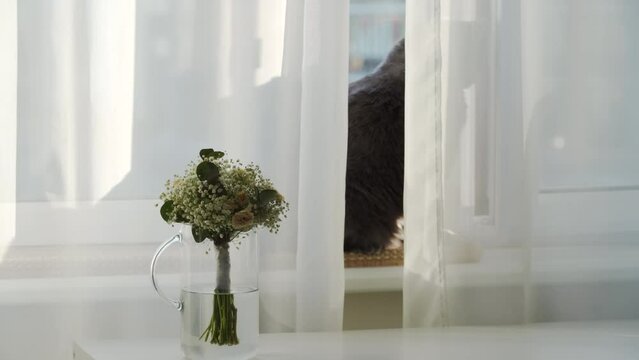 withered white wedding bouquet in a vase by the window