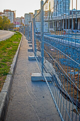 Temporary metal fencing of a construction site on an autumn day