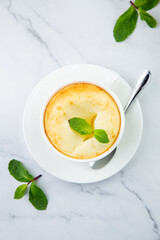 cup of coffee with foam and a sprig of mint on a marble background top view