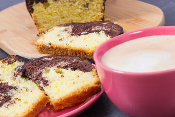 Cup of cappuccino and fresh baked yeast dough with cocoa. Delicious dessert