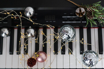 Top view close up shot of piano keyboard and Christmas decoration.