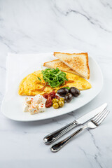 Breakfast of eggs with meat, herbs and drops of sauce with bread in a round plate side view