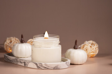 burning candle, cozy minimalist design, autumn atmosphere with white pumpkins and warm lights, copy space