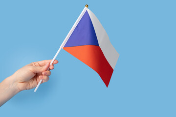 Czech flag in hand on a blue background, copy space, independence national day of Czech, country freedom, patriotism