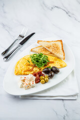 Breakfast of eggs with meat, herbs and drops of sauce with bread in a round plate