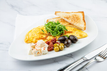 Breakfast of eggs with meat, herbs and drops of sauce with bread in a round plate side view