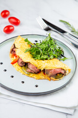 Breakfast of eggs with meat, herbs and drops of sauce in a round plate side view