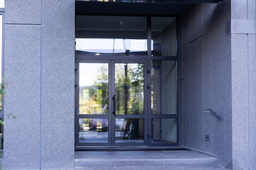 Big rectangular black window in an office building facade with ashlar walling