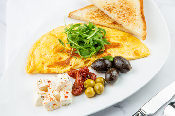 Breakfast of eggs with meat, herbs and drops of sauce with bread in a round plate side view