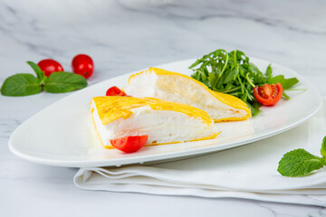 French tall omelette with arugula and cherry tomatoes side view
