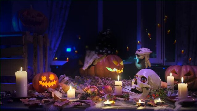 Rotating traditional carved pumpkin waves creepy skeleton hands inviting friends and guests to party holiday  during Halloween celebration. 31 October.