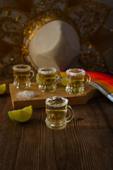 Tequila shots with salt and lime on a bar table. Shots of tequila and typical mexican elements.