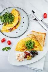 Breakfast of eggs with meat, herbs and drops of sauce with bread in a round plate top view