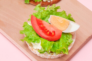 Rice Cake Sandwiches with Tomato, Lettuce and Egg on Wooden Cutting Board. Easy Breakfast. Diet Food. Quick and Healthy Sandwiches. Crispbread with Tasty Filling. Healthy Dietary Snack