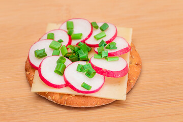 Crispy Cracker Sandwich with Radish, Cheese and Green Onions on Cutting Board. Easy Breakfast. Diet Food. Quick and Healthy Sandwiches. Crispbread with Tasty Filling. Healthy Dietary Snack