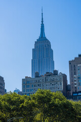 View of empire state building from bryant park in new york city at middle of the day