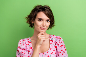 Portrait of positive puzzled girl wear stylish blouse hold finger on chin planing to go shopping isolated on green color background