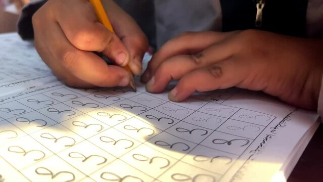 students learn to write Arabic letters