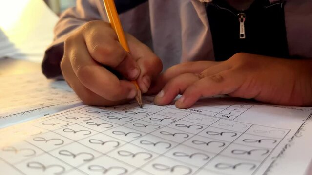 students learn to write Arabic letters